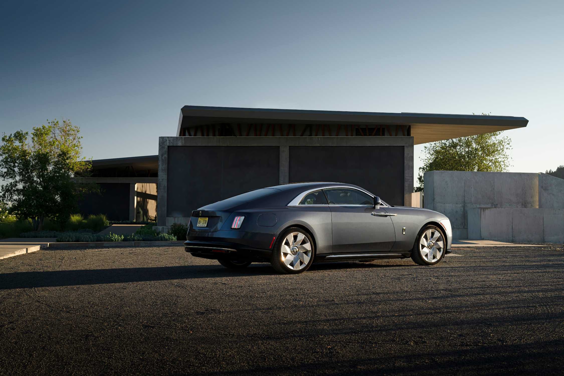 Rolls-Royce Spectre в профиль у современной резиденции
